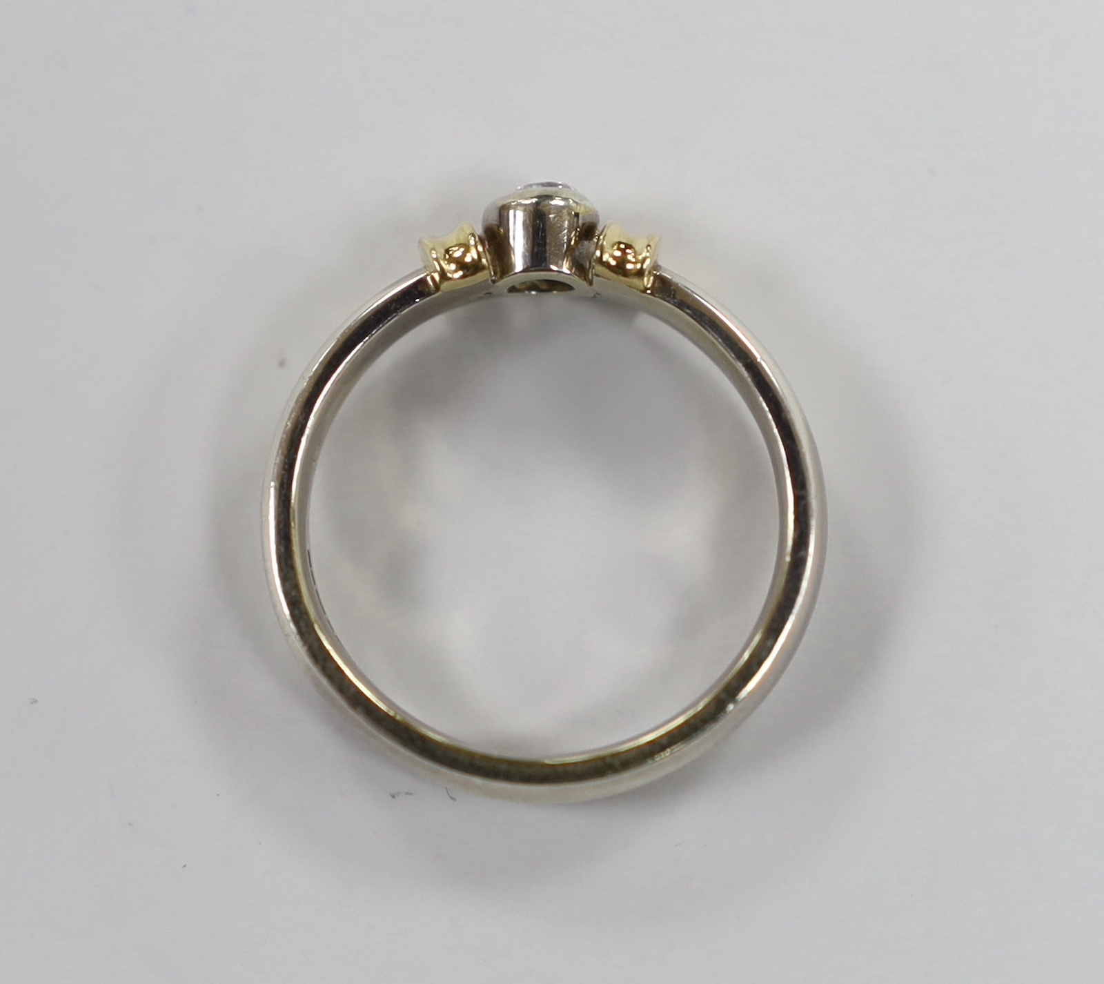 A modern two colour 9ct gold and single stone diamond set ring, size V/W, gross weight 9.1 grams.